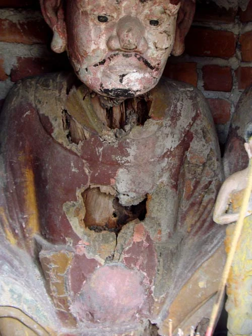 Pho tượng trong tháp mộ bị quan Pháp bắn thủng bụng, cổ.