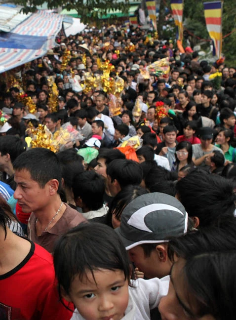 Dòng người náo nức, cuồn cuộn đổ về chùa chính Hương Tích Bị chen lấn cháu bé này òa khóc trên vai bố Không chỉ cháu bé khóc, một cô gái cũng bật khóc Cô gái này thì gần như đã ngất xỉu vì bị chen lấn Một nữ nhà báo đang cố thoát khỏi cảnh người chèn người Ông tây đầy háo hức, chắc lần đầu biết được sự “hấp dẫn” của lễ hội Chùa Hương Một anh công an mồ hôi đầm đìa khi gắng hết sức thực hiện nhiệm vụ giữa đám đông kinh hoàng Cổng động chính chỉ cách vài bước chân nhưng để vào được có khi mất cả giờ đồng hồ Nhiều người không thỏa được nguyện vào động chính đành đứng ngoài bái vọng