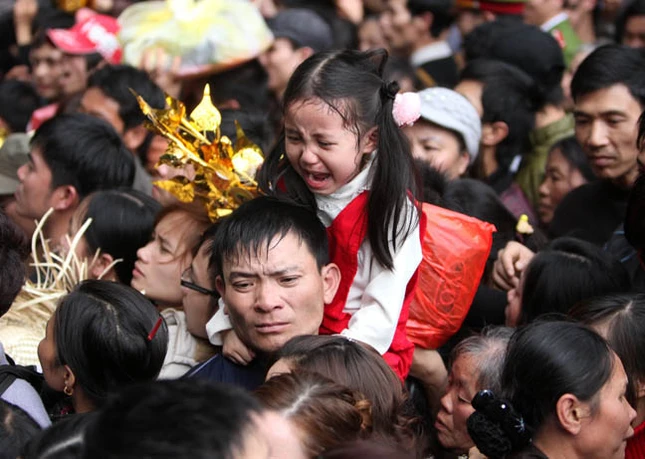 Dòng người náo nức, cuồn cuộn đổ về chùa chính Hương Tích Bị chen lấn cháu bé này òa khóc trên vai bố Không chỉ cháu bé khóc, một cô gái cũng bật khóc Cô gái này thì gần như đã ngất xỉu vì bị chen lấn Một nữ nhà báo đang cố thoát khỏi cảnh người chèn người Ông tây đầy háo hức, chắc lần đầu biết được sự “hấp dẫn” của lễ hội Chùa Hương Một anh công an mồ hôi đầm đìa khi gắng hết sức thực hiện nhiệm vụ giữa đám đông kinh hoàng Cổng động chính chỉ cách vài bước chân nhưng để vào được có khi mất cả giờ đồng hồ Nhiều người không thỏa được nguyện vào động chính đành đứng ngoài bái vọng