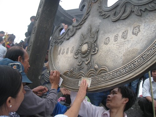 Sát đồng tiền vào chùa Đồng để lấy lộc hình ảnh thiếu văn hoá của du khách. Sát đồng tiền vào chùa Đồng để lấy lộc hình ảnh thiếu văn hoá của du khách.