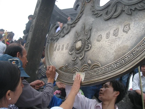 Sát đồng tiền vào chùa Đồng để lấy lộc hình ảnh thiếu văn hoá của du khách.