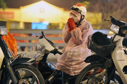 Cảnh đội mưa ngồi kín mít dài gần cây số tại tuyến đường Tây Sơn, gần Tổ đình Phúc Khánh lúc 19h tối 14/1 âm lịch Giao thông tắc nghẽn kéo dài trên tuyến đường này và một số phố giao nối Nhiều người che chắn tập thể bằng một tấm nylon dài, người chưa chuẩn bị đành ngồi đội mưa Tết Nguyên tiêu là ngày lễ thiêng đầu năm mới. Tục truyền, trong ngày rằm tháng Giêng, Đức Phật giáng lâm tại các chùa để chứng giám lòng thành của tín đồ Do đó ngày 14 hoặc chính rằm tháng Giêng, các đền, chùa trở nên quá tải. Tại Hà Nội, chùa Phúc Khánh nổi tiếng là nơi linh thiêng nhất nên thu hút rất đông người dân tới cầu phúc, cầu an Một trong những em bé theo mẹ đến ngồi hàng tiếng đồng hồ trên xe máy trong giá lạnh ngoài phố chờ làm lễ Dải phân cách tại lối lên cầu vượt Ngã Tư Sở cũng chật kín Một cô gái lặng lẽ mặc áo mưa, tay đi găng lầm rầm khấn vái Đứng tràn cả ra lòng đường, cậu thiếu niên này cũng chắp tay làm lễ như người lớn Hết giờ, ghế được giơ cao trên đầu trên đường về Niềm vui sau khi lễ bái thành công và được phát lộc của một người đàn ông Báo, giấy lót chỗ ngồi xả bừa bãi khiến tuyến đường tràn ngập rác