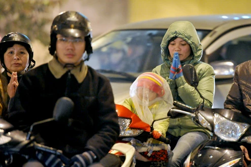 Cảnh đội mưa ngồi kín mít dài gần cây số tại tuyến đường Tây Sơn, gần Tổ đình Phúc Khánh lúc 19h tối 14/1 âm lịch Giao thông tắc nghẽn kéo dài trên tuyến đường này và một số phố giao nối Nhiều người che chắn tập thể bằng một tấm nylon dài, người chưa chuẩn bị đành ngồi đội mưa Tết Nguyên tiêu là ngày lễ thiêng đầu năm mới. Tục truyền, trong ngày rằm tháng Giêng, Đức Phật giáng lâm tại các chùa để chứng giám lòng thành của tín đồ Do đó ngày 14 hoặc chính rằm tháng Giêng, các đền, chùa trở nên quá tải. Tại Hà Nội, chùa Phúc Khánh nổi tiếng là nơi linh thiêng nhất nên thu hút rất đông người dân tới cầu phúc, cầu an Một trong những em bé theo mẹ đến ngồi hàng tiếng đồng hồ trên xe máy trong giá lạnh ngoài phố chờ làm lễ Dải phân cách tại lối lên cầu vượt Ngã Tư Sở cũng chật kín Một cô gái lặng lẽ mặc áo mưa, tay đi găng lầm rầm khấn vái Đứng tràn cả ra lòng đường, cậu thiếu niên này cũng chắp tay làm lễ như người lớn Hết giờ, ghế được giơ cao trên đầu trên đường về Niềm vui sau khi lễ bái thành công và được phát lộc của một người đàn ông Báo, giấy lót chỗ ngồi xả bừa bãi khiến tuyến đường tràn ngập rác