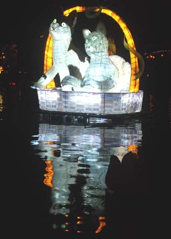 Hàng nghìn du khách trong và ngoài nước đổ về phố cổ Hội An (Quảng Nam) đêm 16/2 để dự lễ hội đèn lồng, thả hoa đăng cầu ước may mắn đầu xuân trên dòng sông Hoài thơ mộng. Đêm Nguyên tiêu, trời chưa tối, khắp các nẻo đường dẫn vào phố cổ Hội An đã lung linh muôn vàn đèn lồng. Dòng người rồng rắn tản bộ dọc Quảng trường Sông Hoài. Đứng lặng nhìn từng đôi tình nhân nâng niu hoa đăng trên tay bước lên chiếc ghe bên bờ sông Hoài, bà Iselin DiBaj, du khách đến từ Na Uy bồi hồi: “Tôi thấy hạnh phúc trong lần đầu tiên đến Việt Nam lại đúng vào dịp trăng tròn. Sông Hoài thật lãng mạn, tôi cứ ngỡ mình đang sống trong miền cổ tích”. Dọc theo sông Hoài, thỉnh thoảng du khách dừng lại trầm trồ, thích thú với các kiểu đèn lồng mang biểu tượng con mèo, phố cổ. Lần đầu đến Hội An vào dịp Nguyên tiêu, anh Trần Công Đức ở TP HCM thích thú chụp ảnh lưu niệm bên những chiếc lồng đèn độc đáo như “Mắt miêu mừng xuân”, “Mèo gánh xuân về phố cổ”, “Hoài Phố”. “Ngồi trên thuyền thong dong giữa dòng sông Hoài, lòng tôi cảm giác thật bình yên, nhẹ nhõm, bao nhiêu phiền toái như biến mất”, anh Đức nói. Du khách nước ngoài chụp ảnh lưu niệm tại một gian hàng bán đèn lồng truyền thống ở đường Nguyễn Phúc Tần, phố cổ Hội An (Quảng Nam) Du khách thích thú chụp ảnh bên đèn lồng mang biểu tượng con mèo bên bờ sông Hoài Các bạn trẻ làm duyên bên đèn lồng “Gánh xuân phố cổ” Đèn lồng đôi mèo soi bóng trên sông Hoài Du khách điệu đà bên quầy bán hoa đăng trong đêm rằm Nguyên tiêu Những người bán hoa đăng tạo thành một dải sáng lung linh bên sông Hoài Sông Hoài lấp lánh ánh đèn Đôi tình nhân người Australia hạnh phúc bên đóa hoa đăng Đôi vợ chồng sắp cưới lãng mạn bên nhau giữa ánh đèn lồng ở phố cổ Hội An đêm Nguyên tiêu. Ảnh: Trí Tín Chở vợ sắp cưới trên chiếc xe đạp vòng quanh phố cổ, anh Tuấn quê ở Đà Nẵng cho hay, suy nghĩ mãi cuối cùng cả hai quyết định chụp ảnh cưới ngoại cảnh, lưu lại khoảnh khắc đẹp của đời mình trong dịp rằm tháng Giêng tại phố cổ. “Hai đứa dắt nhau đi trên những ngõ phố rong rêu, đi thuyền thả hoa đăng cầu mong tình yêu luôn tỏa sáng như đêm rằm tháng Giêng này. Đây cũng là món quà tôi dành tặng người vợ sắp cưới của mình”, Tuấn thổ lộ. Ngoài lễ hội đèn lồng, ngồi trên thuyền thả hoa đăng gieo điều ước đầu xuân mới trên dòng sông Hoài, tại phố cổ, du khách còn được sống hoài niệm trong không gian nghệ thuật truyền thống như trò chơi dân gian đập niêu đậm hồn quê xứ Quảng, thưởng thức làn điệu dân ca bài chòi, đàn tranh, sáo trúc... Trao đổi với VnExpress.net, ông Trương Văn Bay, Phó Chủ tịch UBND thành phố Hội An cho biết, đây là năm thứ hai Hội An tổ chức lễ hội đèn lồng vào dịp đầu xuân, nhằm quảng bá hình ảnh phố cổ đến với bạn bè quốc tế.