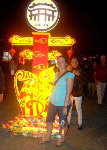 Du khách thích thú chụp ảnh bên đèn lồng mang biểu tượng con mèo bên bờ sông Hoài.