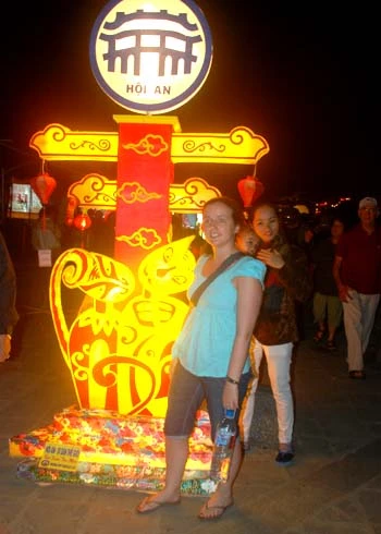Du khách thích thú chụp ảnh bên đèn lồng mang biểu tượng con mèo bên bờ sông Hoài.