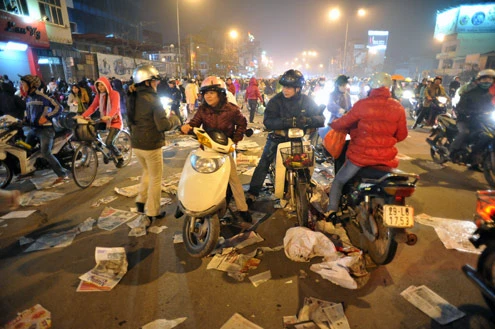 Cảnh đội mưa ngồi kín mít dài gần cây số tại tuyến đường Tây Sơn, gần Tổ đình Phúc Khánh lúc 19h tối 14/1 âm lịch Giao thông tắc nghẽn kéo dài trên tuyến đường này và một số phố giao nối Nhiều người che chắn tập thể bằng một tấm nylon dài, người chưa chuẩn bị đành ngồi đội mưa Tết Nguyên tiêu là ngày lễ thiêng đầu năm mới. Tục truyền, trong ngày rằm tháng Giêng, Đức Phật giáng lâm tại các chùa để chứng giám lòng thành của tín đồ Do đó ngày 14 hoặc chính rằm tháng Giêng, các đền, chùa trở nên quá tải. Tại Hà Nội, chùa Phúc Khánh nổi tiếng là nơi linh thiêng nhất nên thu hút rất đông người dân tới cầu phúc, cầu an Một trong những em bé theo mẹ đến ngồi hàng tiếng đồng hồ trên xe máy trong giá lạnh ngoài phố chờ làm lễ Dải phân cách tại lối lên cầu vượt Ngã Tư Sở cũng chật kín Một cô gái lặng lẽ mặc áo mưa, tay đi găng lầm rầm khấn vái Đứng tràn cả ra lòng đường, cậu thiếu niên này cũng chắp tay làm lễ như người lớn Hết giờ, ghế được giơ cao trên đầu trên đường về Niềm vui sau khi lễ bái thành công và được phát lộc của một người đàn ông Báo, giấy lót chỗ ngồi xả bừa bãi khiến tuyến đường tràn ngập rác