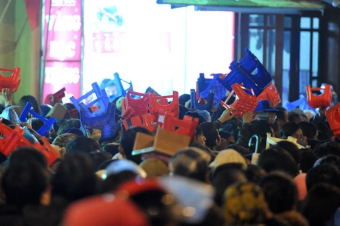 Cảnh đội mưa ngồi kín mít dài gần cây số tại tuyến đường Tây Sơn, gần Tổ đình Phúc Khánh lúc 19h tối 14/1 âm lịch Giao thông tắc nghẽn kéo dài trên tuyến đường này và một số phố giao nối Nhiều người che chắn tập thể bằng một tấm nylon dài, người chưa chuẩn bị đành ngồi đội mưa Tết Nguyên tiêu là ngày lễ thiêng đầu năm mới. Tục truyền, trong ngày rằm tháng Giêng, Đức Phật giáng lâm tại các chùa để chứng giám lòng thành của tín đồ Do đó ngày 14 hoặc chính rằm tháng Giêng, các đền, chùa trở nên quá tải. Tại Hà Nội, chùa Phúc Khánh nổi tiếng là nơi linh thiêng nhất nên thu hút rất đông người dân tới cầu phúc, cầu an Một trong những em bé theo mẹ đến ngồi hàng tiếng đồng hồ trên xe máy trong giá lạnh ngoài phố chờ làm lễ Dải phân cách tại lối lên cầu vượt Ngã Tư Sở cũng chật kín Một cô gái lặng lẽ mặc áo mưa, tay đi găng lầm rầm khấn vái Đứng tràn cả ra lòng đường, cậu thiếu niên này cũng chắp tay làm lễ như người lớn Hết giờ, ghế được giơ cao trên đầu trên đường về Niềm vui sau khi lễ bái thành công và được phát lộc của một người đàn ông Báo, giấy lót chỗ ngồi xả bừa bãi khiến tuyến đường tràn ngập rác