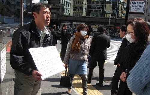 Anh Fujita Takaya, nhân viên một công ty xây dựng, đứng tại nhà ga Tokyo giữa trưa kêu gọi mọi người hỗ trợ các nạn nhân sóng thần và động đất ở tỉnh Sendai - Ảnh: Lan Phương