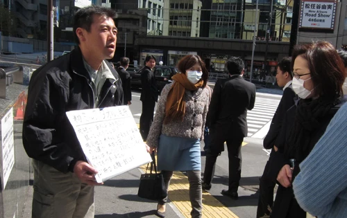 Anh Fujita Takaya, nhân viên một công ty xây dựng, đứng tại nhà ga Tokyo giữa trưa kêu gọi mọi người hỗ trợ các nạn nhân sóng thần và động đất ở tỉnh Sendai - Ảnh: Lan Phương