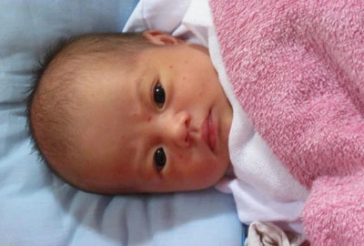 Bé gái có pháp danh Mỹ Lộc tròn xoe đôi mắt trước người lạ đến thăm.