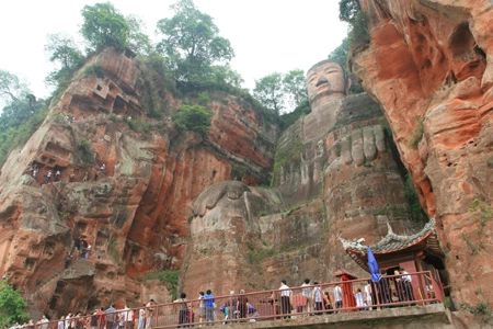 Đoàn người nhi nhít, bé xíu, đi theo những con đường dích dắc để có thể leo lên các vách núi nhằm nhìn gương mặt Phật ở cự ly gần hơn.