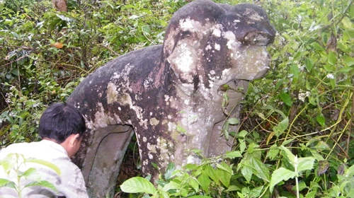 Tượng linh vật bị cây cỏ phủ kín