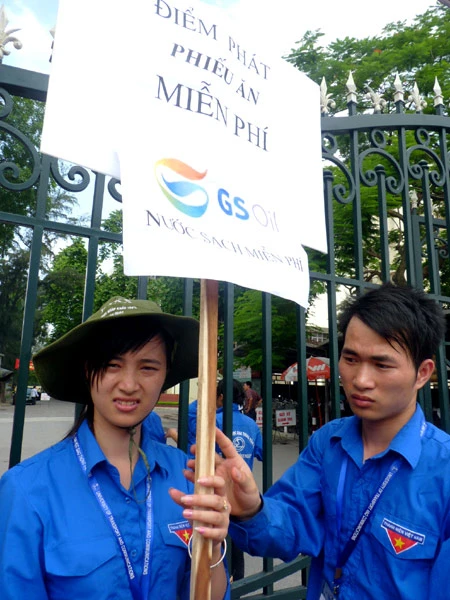 Các tình nguyện viên phát phiếu để nhận cơm (ảnh: Dân trí)