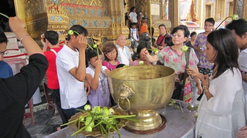 Rảy nước lên đầu, mặt cầu mong sự mát mẻ, tốt lành sau lễ chùa.