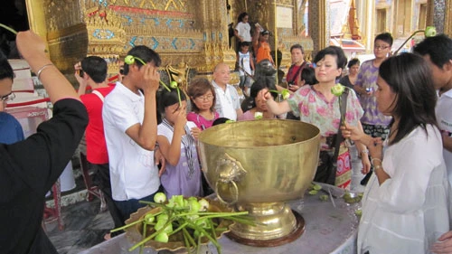 Rảy nước lên đầu, mặt cầu mong sự mát mẻ, tốt lành sau lễ chùa.