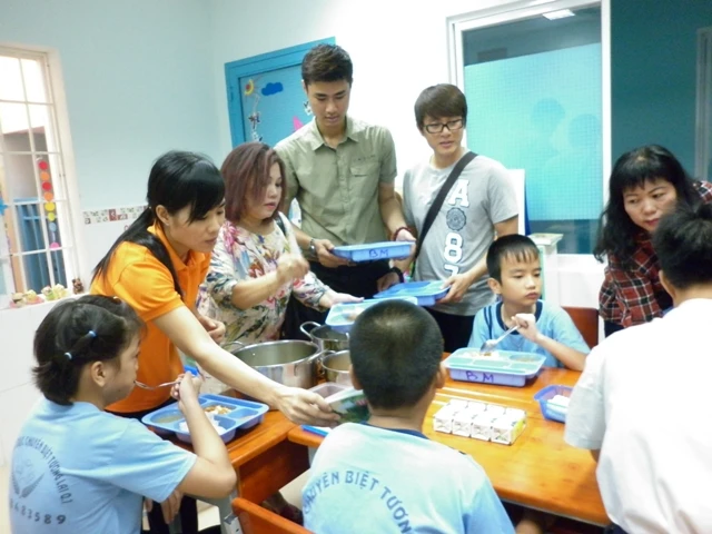 ca sĩ siu Black và diễn viên Hòa Hiệp múc cơm cho các bé.JPG