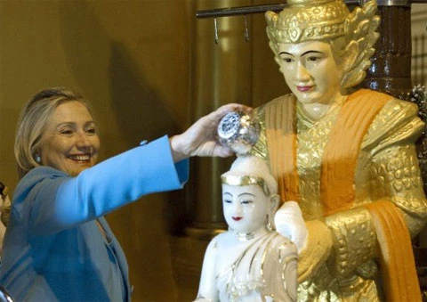Bà Clinton đổ nước lên một bức tượng Phật tại chùa Shwedagon. Ảnh: AFP