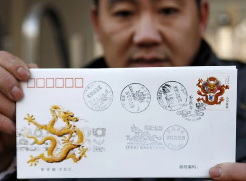 Các công nhân đang lắp đặt đèn lồng khổng lồ hình con rồng trên một hồ nước để chào đón năm mới Âm lịch ở Suining, tỉnh Tứ Xuyên. Năm mới cổ truyền ở Trung Quốc sẽ bắt đầu từ ngày 23/1 Dương lịch. Những người đàn ông Trung Quốc múa rồng trên một hồ nước đóng băng chào đón năm mới ở Shenyang, tỉnh Liêu Ninh ngày 1/1/2012. Thợ lặn múa rồng trong một sự kiện chào đón năm mới Âm lịch ở trong một bể cá tại Bắc Kinh ngày 5/1/2012. Công nhân trang trí một bức tượng hình con rồng để chuẩn bị cho một sự kiện chào đón năm mới cổ truyền ở Ôn Châu, Chiết Giang ngày 9/1. Một công nhân xịt sơn cho bộ phận của chiếc đèn lồng hình người, để chuẩn bị cho một sự kiện chào đón năm mới ở Suining, Tứ Xuyên. Công nhân đang lắp đặt một đèn lồng hình rồng ở trên tường ở Nam Kinh. Du khách chụp hình chiếc đèn lồng hình rồng rực sáng trong đêm ở Bắc Kinh ngày 7/1. Người mẫu đội một chiếc mũ làm từ chocolate, tại sự kiện Chocolate Thế giới ở Thượng Hải để chào đón năm mới. Học sinh cầm câu đối, đèn lồng và múa rồng để chào đóng năm mới tại một ngôi trường tiểu học tại Cửu Giang, Giang Tây. Công nhân nhập cư dùng bữa tại một công trường ở Thành Đô, Trung Quốc ngày 9/1. Hơn 1.400 công nhân nhập cư đã tham gia bữa ăn thường niên để chào mừng năm mới. Đèn lồng trang hoàng rực rỡ tại một con phố ở Zibo, Trung Quốc ngày 8/1. Công nhân đang dựng một bức tượng hình Quan Âm trên những chiếc đèn lồng hình rồng ở Tứ Xuyên ngày 7/1. Một giáo viên đang cho các học sinh xem bức tranh hình rồng ở một ngôi trường tiểu học tại tỉnh Sơn Đông ngày 5/1. Người đàn ông giơ bức thư có gắn tem hình rồng tại Huaibei, tỉnh An Huy ngày 5/1. Tem thư được thiết kế có hình rồng này đã gây ra sự chỉ trích của người dân, khi họ cho rằng con rồng này có hình dáng quá hung tợn.