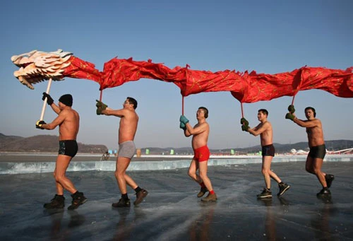 Các công nhân đang lắp đặt đèn lồng khổng lồ hình con rồng trên một hồ nước để chào đón năm mới Âm lịch ở Suining, tỉnh Tứ Xuyên. Năm mới cổ truyền ở Trung Quốc sẽ bắt đầu từ ngày 23/1 Dương lịch. Những người đàn ông Trung Quốc múa rồng trên một hồ nước đóng băng chào đón năm mới ở Shenyang, tỉnh Liêu Ninh ngày 1/1/2012. Thợ lặn múa rồng trong một sự kiện chào đón năm mới Âm lịch ở trong một bể cá tại Bắc Kinh ngày 5/1/2012. Công nhân trang trí một bức tượng hình con rồng để chuẩn bị cho một sự kiện chào đón năm mới cổ truyền ở Ôn Châu, Chiết Giang ngày 9/1. Một công nhân xịt sơn cho bộ phận của chiếc đèn lồng hình người, để chuẩn bị cho một sự kiện chào đón năm mới ở Suining, Tứ Xuyên. Công nhân đang lắp đặt một đèn lồng hình rồng ở trên tường ở Nam Kinh. Du khách chụp hình chiếc đèn lồng hình rồng rực sáng trong đêm ở Bắc Kinh ngày 7/1. Người mẫu đội một chiếc mũ làm từ chocolate, tại sự kiện Chocolate Thế giới ở Thượng Hải để chào đón năm mới. Học sinh cầm câu đối, đèn lồng và múa rồng để chào đóng năm mới tại một ngôi trường tiểu học tại Cửu Giang, Giang Tây. Công nhân nhập cư dùng bữa tại một công trường ở Thành Đô, Trung Quốc ngày 9/1. Hơn 1.400 công nhân nhập cư đã tham gia bữa ăn thường niên để chào mừng năm mới. Đèn lồng trang hoàng rực rỡ tại một con phố ở Zibo, Trung Quốc ngày 8/1. Công nhân đang dựng một bức tượng hình Quan Âm trên những chiếc đèn lồng hình rồng ở Tứ Xuyên ngày 7/1. Một giáo viên đang cho các học sinh xem bức tranh hình rồng ở một ngôi trường tiểu học tại tỉnh Sơn Đông ngày 5/1. Người đàn ông giơ bức thư có gắn tem hình rồng tại Huaibei, tỉnh An Huy ngày 5/1. Tem thư được thiết kế có hình rồng này đã gây ra sự chỉ trích của người dân, khi họ cho rằng con rồng này có hình dáng quá hung tợn.