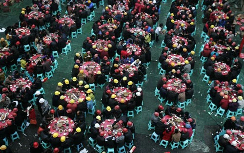 Các công nhân đang lắp đặt đèn lồng khổng lồ hình con rồng trên một hồ nước để chào đón năm mới Âm lịch ở Suining, tỉnh Tứ Xuyên. Năm mới cổ truyền ở Trung Quốc sẽ bắt đầu từ ngày 23/1 Dương lịch. Những người đàn ông Trung Quốc múa rồng trên một hồ nước đóng băng chào đón năm mới ở Shenyang, tỉnh Liêu Ninh ngày 1/1/2012. Thợ lặn múa rồng trong một sự kiện chào đón năm mới Âm lịch ở trong một bể cá tại Bắc Kinh ngày 5/1/2012. Công nhân trang trí một bức tượng hình con rồng để chuẩn bị cho một sự kiện chào đón năm mới cổ truyền ở Ôn Châu, Chiết Giang ngày 9/1. Một công nhân xịt sơn cho bộ phận của chiếc đèn lồng hình người, để chuẩn bị cho một sự kiện chào đón năm mới ở Suining, Tứ Xuyên. Công nhân đang lắp đặt một đèn lồng hình rồng ở trên tường ở Nam Kinh. Du khách chụp hình chiếc đèn lồng hình rồng rực sáng trong đêm ở Bắc Kinh ngày 7/1. Người mẫu đội một chiếc mũ làm từ chocolate, tại sự kiện Chocolate Thế giới ở Thượng Hải để chào đón năm mới. Học sinh cầm câu đối, đèn lồng và múa rồng để chào đóng năm mới tại một ngôi trường tiểu học tại Cửu Giang, Giang Tây. Công nhân nhập cư dùng bữa tại một công trường ở Thành Đô, Trung Quốc ngày 9/1. Hơn 1.400 công nhân nhập cư đã tham gia bữa ăn thường niên để chào mừng năm mới. Đèn lồng trang hoàng rực rỡ tại một con phố ở Zibo, Trung Quốc ngày 8/1. Công nhân đang dựng một bức tượng hình Quan Âm trên những chiếc đèn lồng hình rồng ở Tứ Xuyên ngày 7/1. Một giáo viên đang cho các học sinh xem bức tranh hình rồng ở một ngôi trường tiểu học tại tỉnh Sơn Đông ngày 5/1. Người đàn ông giơ bức thư có gắn tem hình rồng tại Huaibei, tỉnh An Huy ngày 5/1. Tem thư được thiết kế có hình rồng này đã gây ra sự chỉ trích của người dân, khi họ cho rằng con rồng này có hình dáng quá hung tợn.