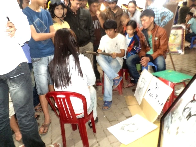 một họa sỹ trẻ đang trổ tài vẻ chân dung.JPG