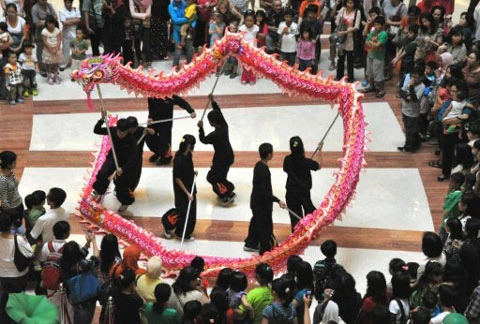 Đội múa rồng biểu diễn trước sự theo dõi của rất nhiều người dân tại một trung tâm mua sắm ở thủ đô Jakarta của Indonesia. Ảnh: AFP