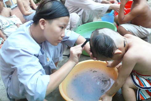 "Phủi tóc" là nghi lễ mang tính truyền thống hàng năm với trẻ mồ côi ở chùa Phật Minh. Ảnh: Phương Yến