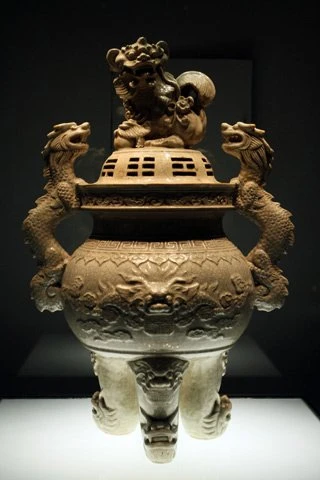 Đỉnh trang trí rồng và nghê được làm bằng chất liệu gốm men rạn, triều Lê Trung Hưng, niên hiệu Vĩnh Hựu năm thứ 2 (1736), làng gốm Bát Tràng.