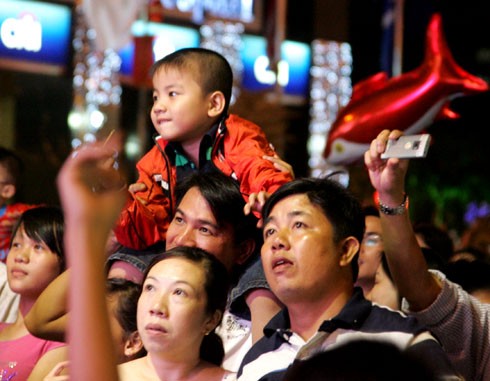 Bố mẹ cỗng con cùng xem pháo hoa.