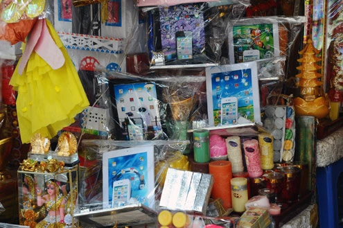 Còn 3 ngày nữa đến lễ Vu lan, phố Hàng Mã ở thủ đô lại nhộn nhịp cảnh mua bán vật dụng cho người cõi âm Một "trạm bán xăng dầu" mới xuất hiện trên sạp hàng. Theo chủ hàng, giá bán từ 150.000 đồng đến 200.000 đồng "Khách hàng nói là khi đi gọi hồn, người nhà ở dưới than phiền được tặng ôtô, xe máy nhưng chẳng có xăng để chạy nên toàn bỏ xó. Vì vậy họ đã đặt sản xuất một cây xăng để cúng", một người bán hàng nói Những mặt hàng xuất hiện nhiều trong năm nay là những chiếc máy tính bảng, giá từ vài chục nghìn đến hơn 100.000 đồng Những máy tính bảng giấy này được thiết kế chủ yếu nhái theo mẫu iPhone 4S, iPad3 Những mặt hàng thông dụng như máy giặt, điều hoà, bếp ga... vẫn được tiêu thụ nhiều. Họ quan niệm mình sống trên trần gian như thế nào, ở dưới cõi âm cũng vậy Váy cho trẻ em đủ màu sắc, kiểu dáng Tivi LCD kích cỡ to y như thật Tiền âm phủ làm giống tiền thật dù bị cấm vẫn ngang nhiên bày bán Dịch vụ chở đến tận nhà khách hàng