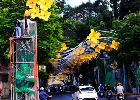 Nhiều tòa nhà lớn ở trung tâm thành phố căng panô, áp phích, đường phố cũng được dọn dẹp thông thoáng để chuẩn bị cho nhiều hoạt động đón năm mới. Đường Đồng Khởi, hệ thống chiếu sáng tiếp tục được lắp đặt, bên cạnh hoa trang trí từ Tết dương lịch. Nhiều con đường ánh sáng sẽ nối tiếp nhau ở trung tâm thành phố. Cổng chào được dựng lên ở công viên Tao Đàn. Tại đây, từ 25 tháng Chạp sẽ khai mạc hội hoa xuân với 8.000 hiện vật về hoa, cây cảnh của các nghệ nhân trong và ngoài nước. Người dân ở nhiều khu chung cư cũng tự bỏ tiền ra sơn sửa lại. Đường hoa Nguyễn Huệ sẽ khai mạc từ sáng 27 Tết. Theo ban tổ chức, chủ đề 2013 sẽ đưa đến các biểu trưng về đất nước. Dọc đường Nguyễn Huệ, các hình khối đã bắt đầu được dựng lên, thành phố sẽ cấm xe trong thời gian tới nhằm đảm bảo việc thi công và lắp đặt các mảng hoa trang trí. Công nhân đang ghép các cành hoa trên đường Phạm Ngọc Thạch, khu trung tâm gần nhà thờ Đức Bà này dự tính sẽ rực vàng trong những ngày xuân Quý Tỵ. Trong khi đó, hoa tươi đã được vận chuyển về trung tâm, lắp ghép ở hai bên đường. Nhiều trung tâm mua sắm, siêu thị trong thành phố đã rực vàng không khí đón năm mới. Năm nay, dù kinh tế khó khăn, sức mua giảm, nhưng các trang trí đón xuân hầu như vẫn được giữ nguyên. Một chiếc đèn lồng khổng lồ trang trí trong một trung tâm thương mại. Trong khi đó, các hoạt động như gói bánh chưng, bánh tét, tìm hiểu về tục lệ Xuân thu hút giới trẻ tham gia. Từ nay tới Tết Nguyên đán, các hoạt động như hội hoa xuân, phố ông đồ sẽ liên tiếp diễn ra. Phần lớn các hoạt động này đều có sự tham gia của các doanh nghiệp.