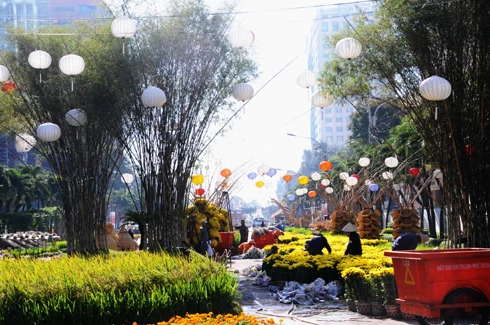 Sau những tuyến đường lớn như Đồng Khởi, Lê Duẩn, Lê Lợi, một số phố khác ở trung tâm thành phố cũng hoàn thành việc trang trí Tết. Đây là năm mà TP HCM có nhiều tuyến được thắp sáng bằng các dải đèn màu, theo từng chủ đề khác nhau. Thương xá Tax năm nay lấy màu hoa mai làm chủ đạo với ánh đèn đỏ, ấm vàng. Bên dưới là các trang trí Tết, từ 18h, rất đông người đến chụp ảnh và ngắm không khí xuân. Trong khi đó, từ các cửa hiệu lớn... ... đến các trung tâm thương mại, khách sạn bắt đầu trang trí bằng ánh sáng đủ màu. Đường hoa Nguyễn Huệ đang bước vào những ngày cuối cùng trước khi khai mạc sáng 27 tháng Chạp. Các biểu tượng năm rắn và quê hương đất nước đã gần hoàn thành. Những công nhân đang tưới các giò hoa treo cao. Mỗi chủ đề trên con đường hoa năm nay được dàn dựng bằng các hình ảnh mang cảnh sắc quen thuộc của Việt Nam. Rặng tre, ruộng lúa và khóm hoa xuất hiện giữa đường. Nhiều tuyến phố trung tâm thành phố được trang trí bằng đủ các loại hoa sặc sỡ. Tượng đài Hồ Chủ tịch trước UBND thành phố với sen chủ đạo và các cánh hoa màu sắc khác nhau. Các con thuyền hoa bên cạnh hồ Bán nguyệt, quận 7. Các hội chợ, lễ hội hoa đã diễn ra từ ngày 23 tháng Chạp. Năm nay, hoa từ các tỉnh miền Tây và phía Bắc chuyển về nhiều, mức giá vừa phải. Trong những ngày đầu mở cửa, lượng khách vãn cảnh nhiều, nhưng người mua ít.