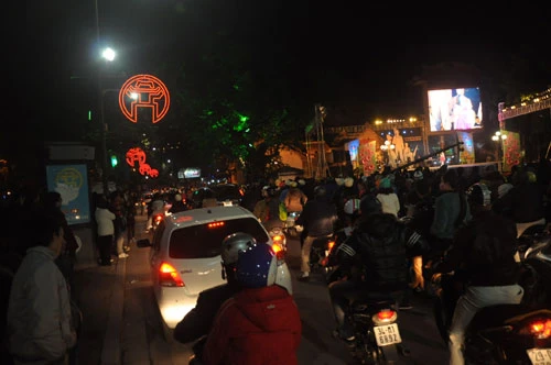 Dòng người bắt đầu hối hả tìm chỗ dừng chân đón giao thừa. Đã khá nhiều người tập trung trước các khu sân khấu quanh bờ hồ. 2 người lính đứng gác trước khu vực bố trí dàn pháo bắn pháo hoa. Rất nhiều người muốn chụp ảnh với những người lính này. Bữa ăn vội của lính cứu hỏa ngay trên cabin trước giờ giao thừa.