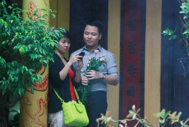 Hai bạn trẻ cầm trên tay đóa hoa hồng, họ may mắn khi vẫn còn Cha mẹ.