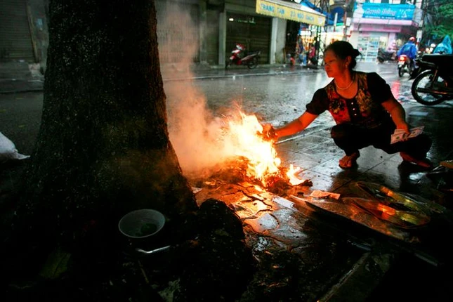 Dọc các con đường, người dân đốt vàng mã ngay tại vỉa hè. Bà Xuân cho biết, năm nay kinh tế khó khăn nên đồ hàng mã làm lễ không phong phú và nhiều như mọi năm.