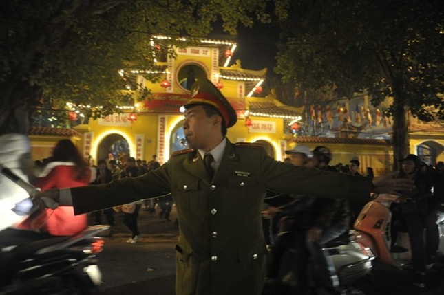 Anh Trần Thanh Tùng, công an phường Quán Sứ vất vả phân luồng trước cửa chùa.