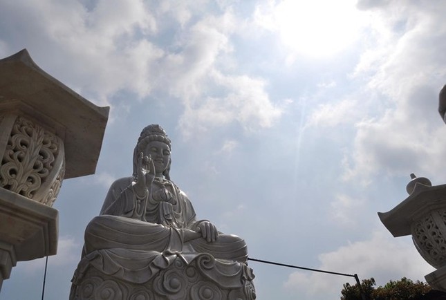 Cô Tuyền (48 tuổi), một Phật tử gần cổng chùa cho biết, pho tượng mới được tọa lạc ở đây được vài tháng. Pho tượng Quan Thế Âm Bồ-tát trong tư thế tọa trên đài sen từ bi được làm từ đá trắng nguyên khối. Xung quanh bệ đài sen lớn có rất nhiều nụ, lá sen bằng đá mọc từ dưới chân tượng lên. Mặt trước và sau pho tượng có khắc một bài kinh Phật bằng chữ nho được sơn vàng. Từ ngày có pho tượng, các Phật tử trong làng ngoài xã cứ tối thứ bảy, chủ nhật hàng tuần đến tụng kinh lễ Phật rất đông. Cận cảnh Quan Thế Âm Bồ-tát tọa đài sen. 4_jpg.jpg