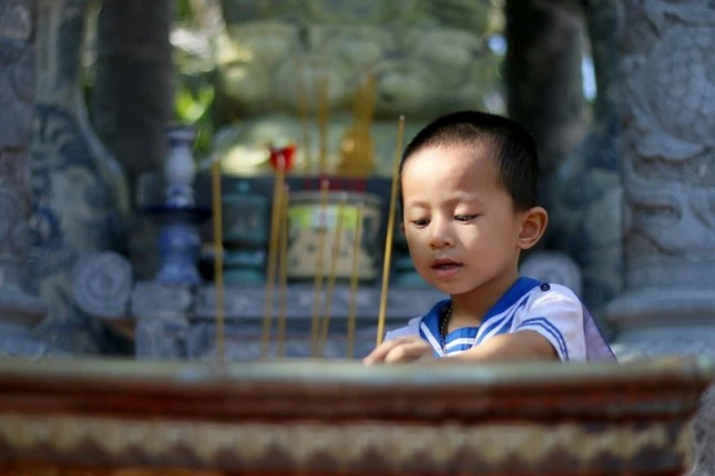 Cháu Nguyễn Quốc Duy (3 tuổi) theo mẹ lên chùa - Ảnh: Ngọc Hiển