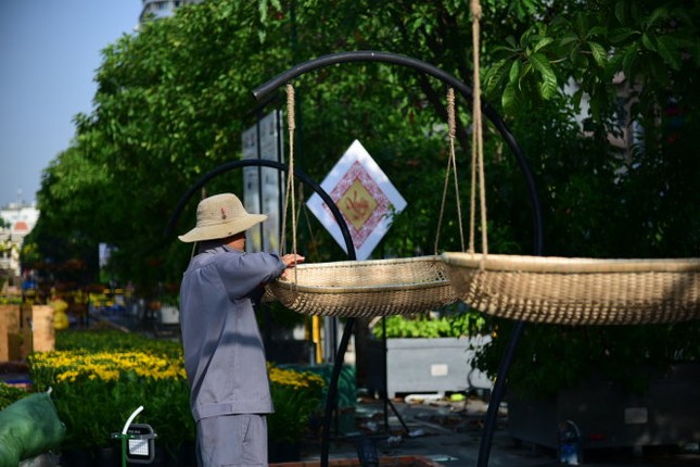 Công nhân đang lắp đặt những lẵng đựng hoa bằng tre đan - Ảnh: HỮU THUẬN Ngắm đường hoa Nguyễn Huệ Tết Đinh Dậu 2017 trước khai mạc