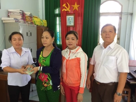 PCT UBND xa Tan Phu trao tien ban  doc bao GN giup chi Hoa chua benh.jpg