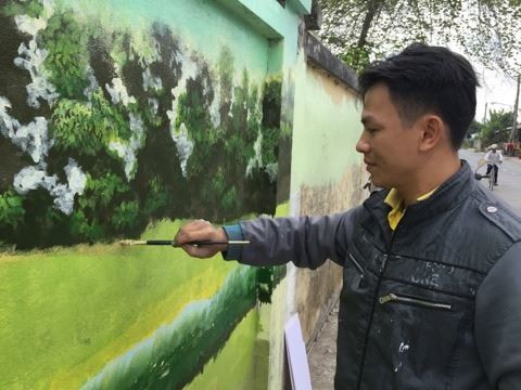 Anh Doanh dang ve tranh tren tuong.jpg