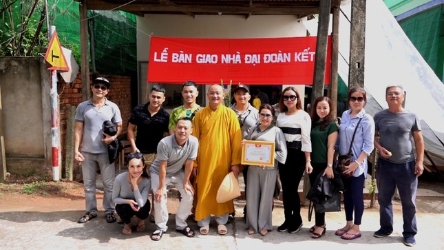 Đoàn phật tử chụp ảnh lưu niệm với gia đình chị Tâm trước căn nhà mới.jpg