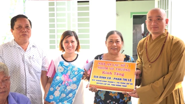 Đại đức Thích Minh Chánh Trụ trì chùa Linh Thứu cùng Ct UBMTTQVN TT Lấp Vò trao bảng nhà cho hộ nghèo Phan Thị Lệ.jpg