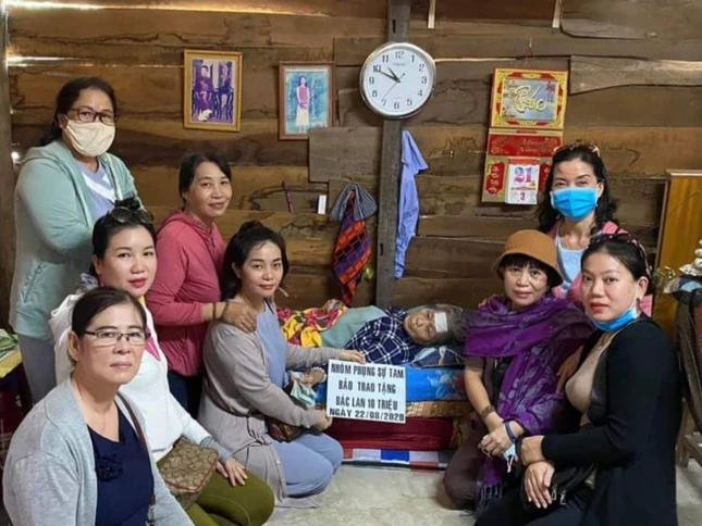 Nhóm thiện nguyện trao tiền cho bà Lan đang nằm tại nhà.jpg