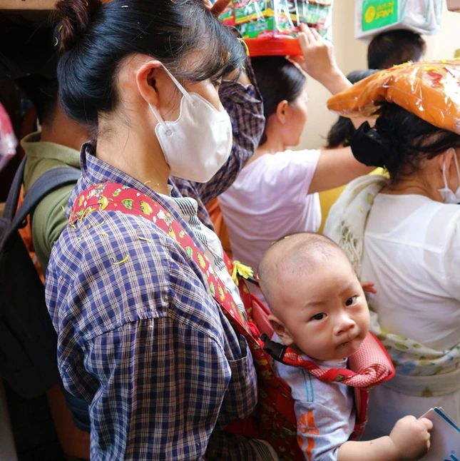 Một Phật tử trẻ địu con tham gia lễ dâng y Kathina tạichùa Siêu Lý (quận 6, TP.HCM) - Ảnh: Khánh Vi trangtre.1077.3.jpg