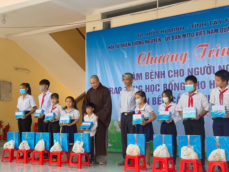 Đại đức Thích Minh Phú tặng quà cho học sing nghèo - Ảnh: TN