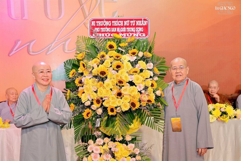 Ni sư Thích nữ Huệ Dâng, Trưởng Tiểu ban Hướng dẫn Phật tử đón nhận lẵng hoa chúc mừng từ Ni trưởng Thích nữ Từ Nhẫn, Phó trưởng Phân ban Ni giới T.Ư
