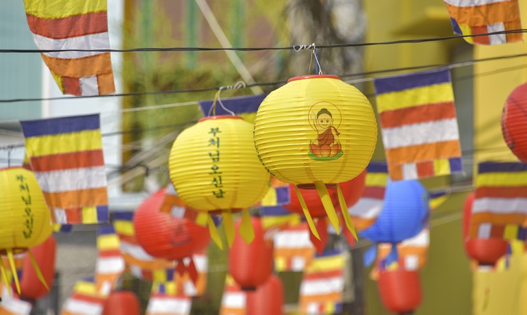 Lồng đèn và cờ Phật giáo đầy sắc màu treo trước cổng Linh Quang tịnh xá - lễ đài Phật đản của GHPGVN Q.4 - Ảnh: Quảng Đạo