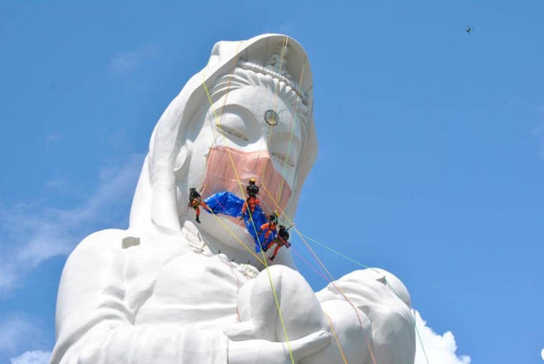Nhiều ý kiến về việc đeo khẩu trang cho tượng Bồ-tát Quán Thế Âm - Ảnh: CBS